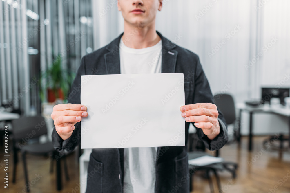 cropped shot of young man holding blank paper cropped shot of young man holding blank paper