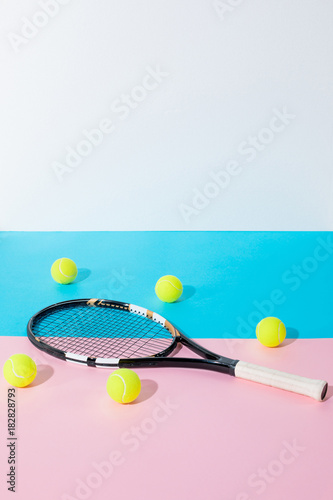 tennis racket and yellow balls on blue and pink papers with copy space © LIGHTFIELD STUDIOS