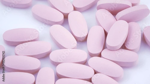 Oval pink tablets on plate photo