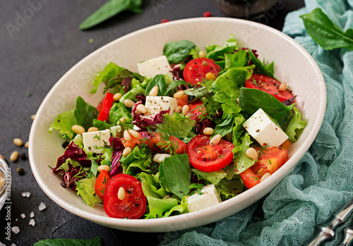 Dietary salad with tomatoes, feta, lettuce, spinach and pine nuts.