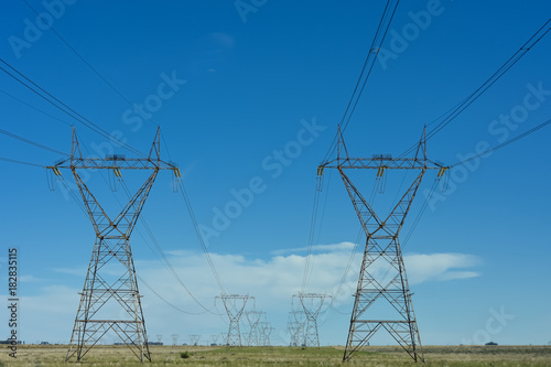 Electric power lines against blue sky