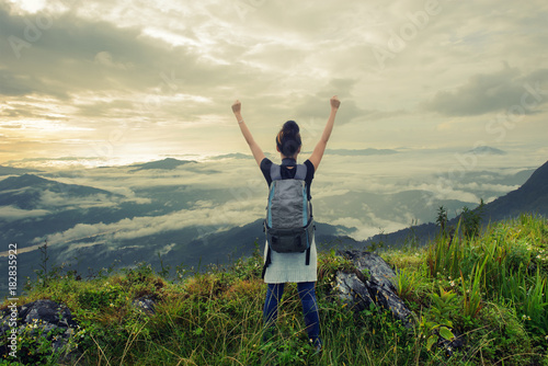 woman tourists standing arms up on the hill at Doi pha tang number 103 in chiangrai tourist attraction in thailand