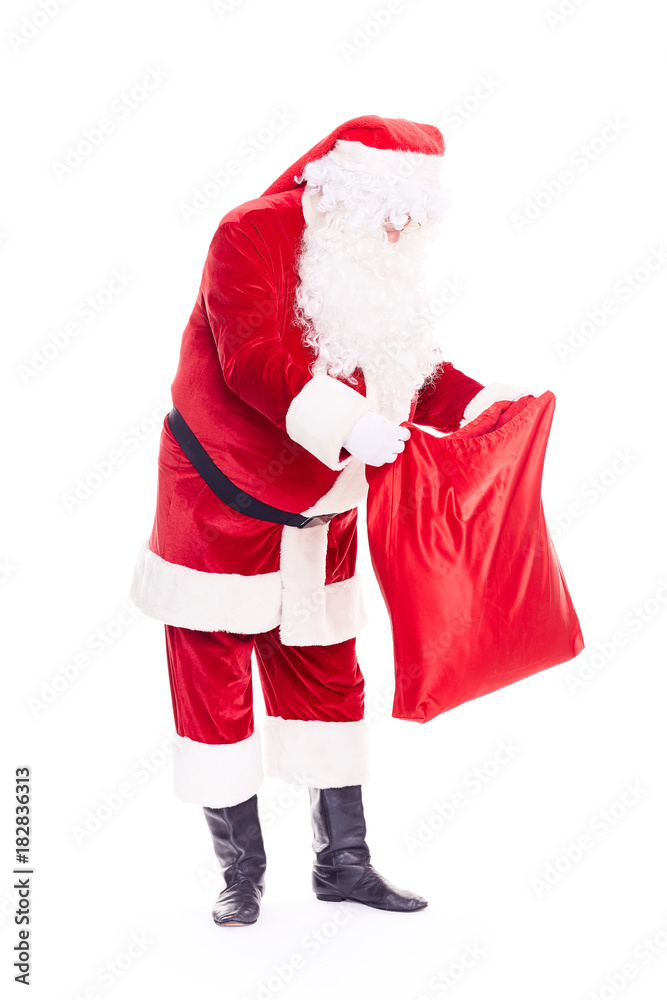 Portrait of Christmas character Santa Claus in traditional costume with red sack on white background