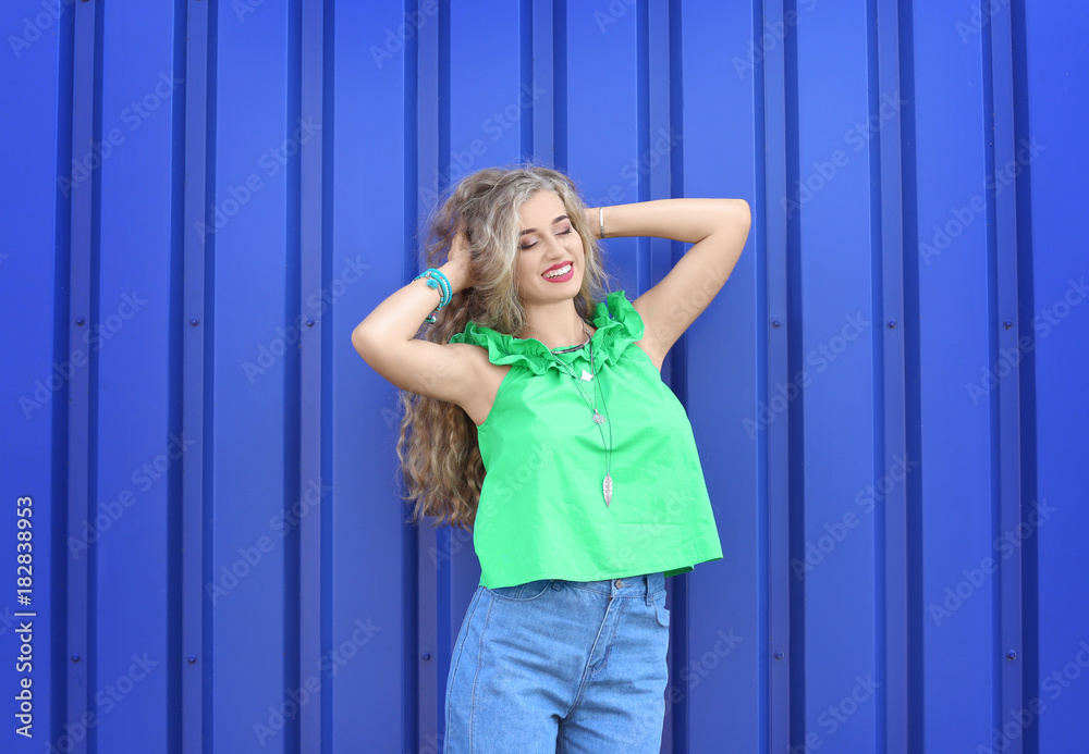 Fototapeta premium Attractive hipster girl posing near color wall