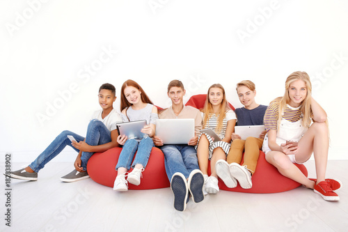Teenagers with modern gadge...