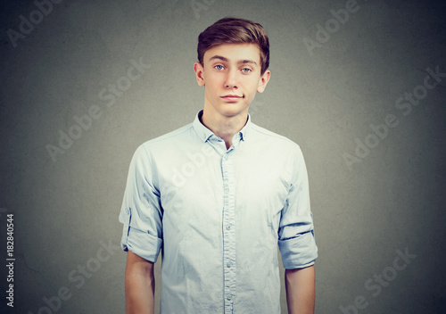 Portrait of skeptical young man looking suspicious, with some disgust on his face mixed with disapproval