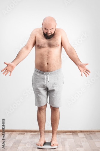 Overweight man measuring hi...