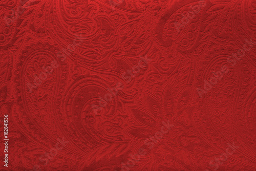 Red velvet fabric with a vintage elegant floral pattern or a luxury texture.