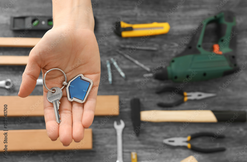 Fototapeta premium Real estate agent holding key with trinket on blurred background
