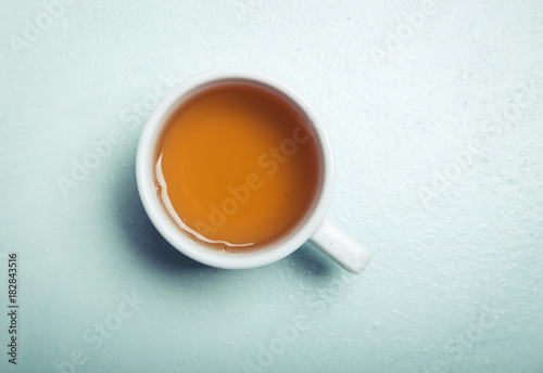 Cup with green tea on grey wooden background
