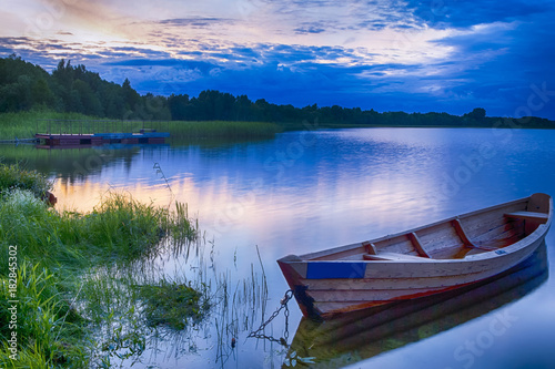 Travel Destinations Concepts. Tranquil and Peaceful Picturesque Landscape of The Strusto Lake with Wooden Boat at Foreground. Lake is a Part of National Braslav Lakes Reserve.