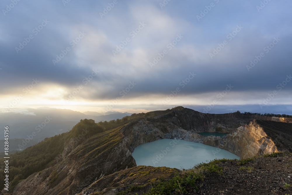 The sun illuminates the edge of Danau Kootainuamuri the middle crater lake at Kelimutu National Park in Indonesia.