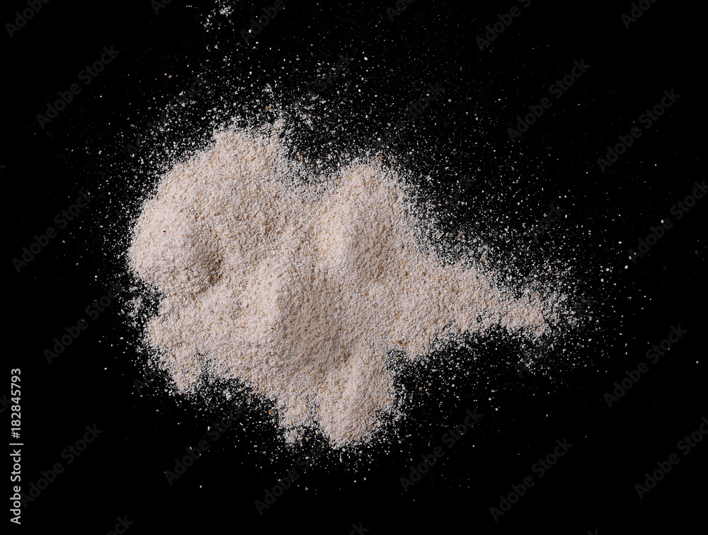 Pile of integral whole grain barley flour isolated on black background