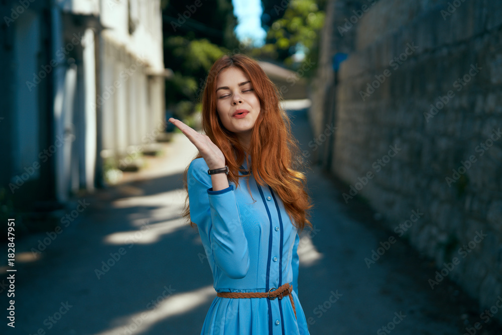 Young beautiful woman is walking along the city street