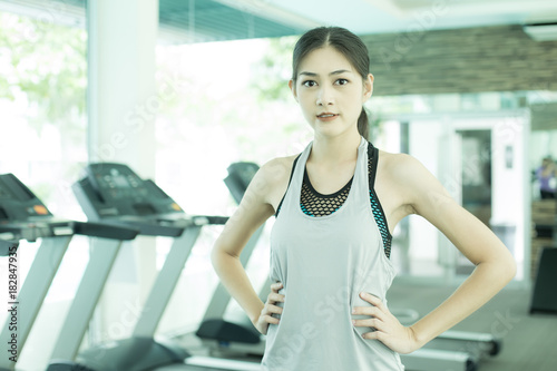Free Download Portrait of a young Attractive Asian Woman iat Fitness Club. Woman with Exercise Concept. - GFXLoad