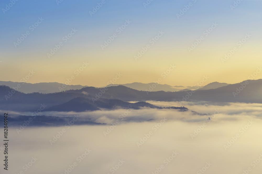   High angle view over tropical rainforest mountains with white fog in early morning
