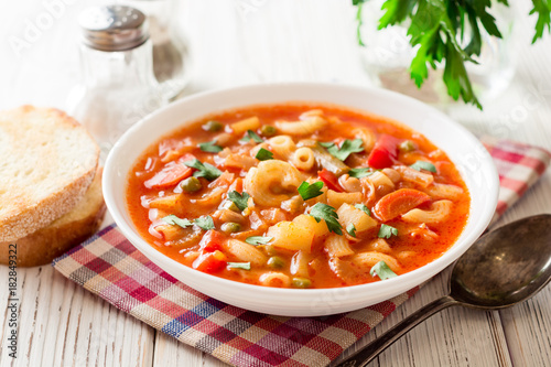 Italian minestrone soup on white wooden background.