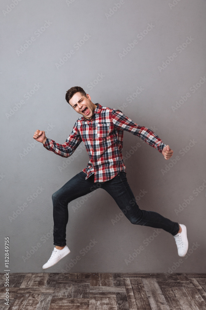 Full length image of happy man in shirt and jeans