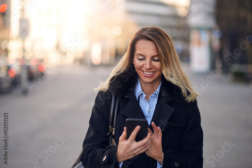 Modische Geschäftsfrau mit Ihrem Handy auf der Straße