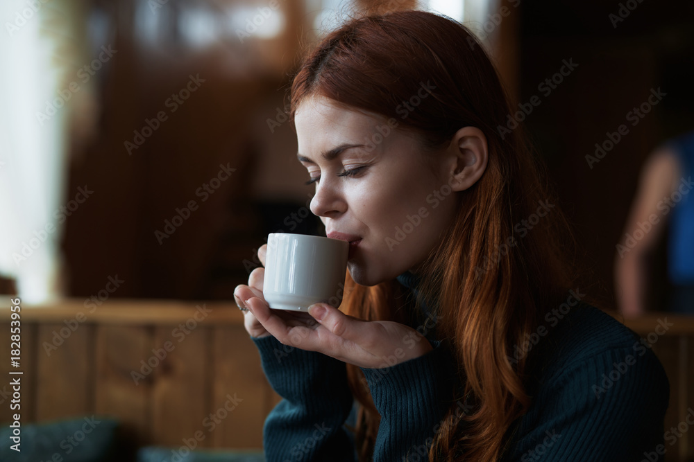 Beautiful young woman drinks coffee in a cafe Beautiful young woman drinks coffee in a cafe