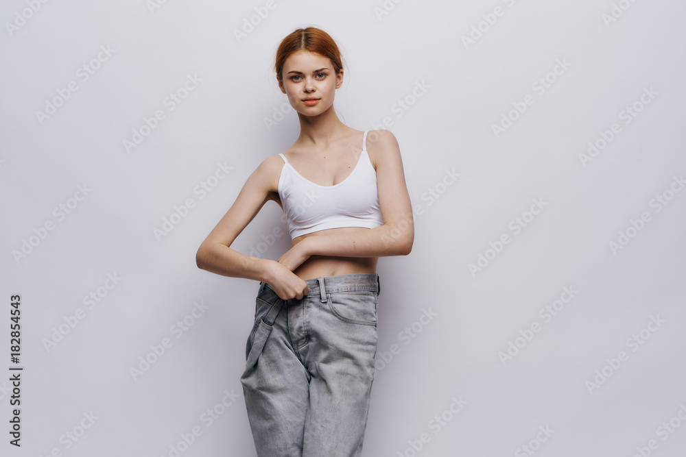 Beautiful young woman on a light background, diet, weight loss, progress, success Beautiful young woman on a light background, diet, weight loss, progress, success