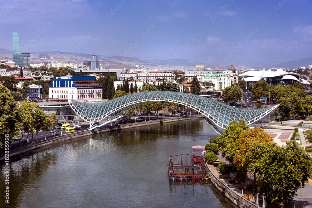 Kingdom of Georgia, Tbilisi (Tiflis): Panoramic view with Bridge of Peace over Kura river with, Serice Hall, National Bank, skyscrapers and skyline of the Georgian capital in the background. 