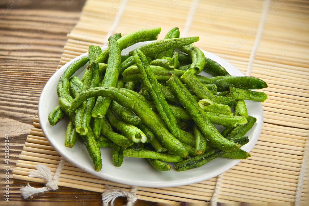 green beans pods on awhite plate on table green beans pods on awhite plate on table