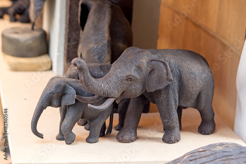 The carve elephants made from the wood stand on the shelf