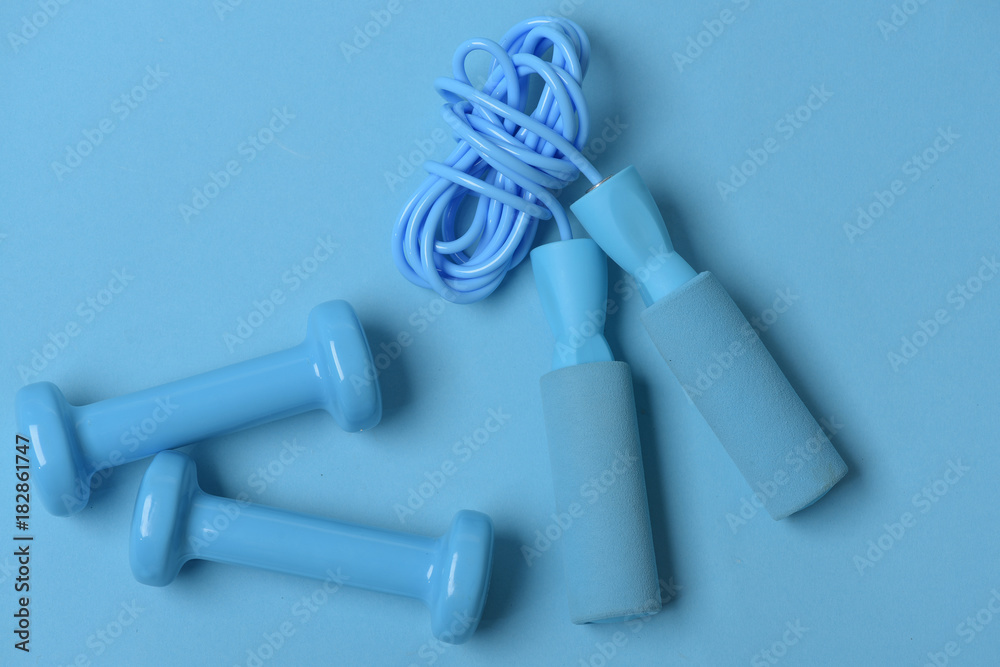 Jump rope and barbells placed next to each other Jump rope and barbells placed next to each other