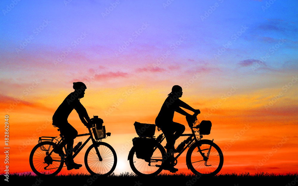 Fototapeta premium Silhouette man and bike relaxing on blurry sunrise background