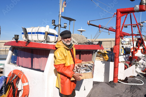 fisherman with a fish box inside a fishing boat