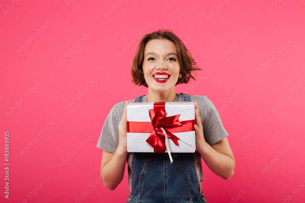 Emotional young woman holding gift box. Emotional young woman holding gift box.