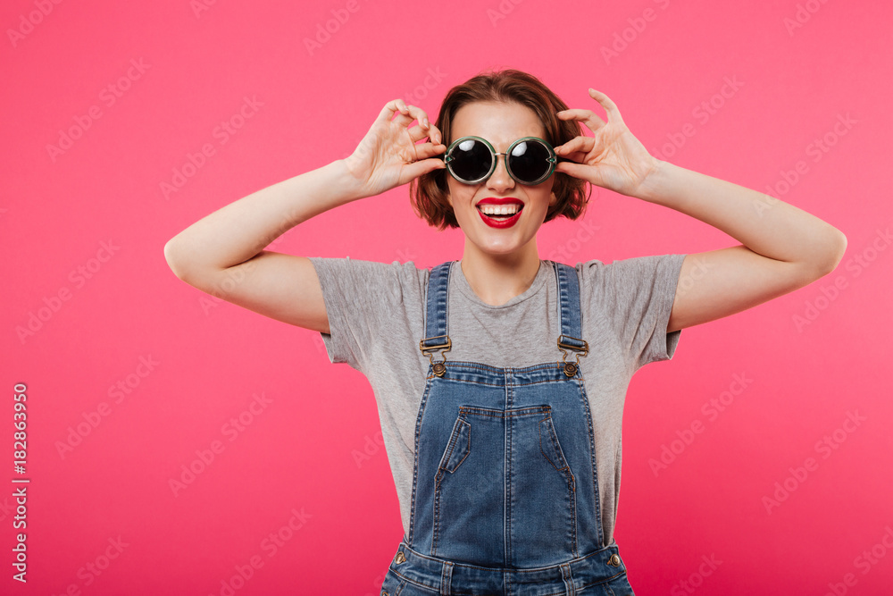 Cheerful young woman wearing sunglasses. Cheerful young woman wearing sunglasses.