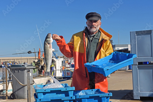 Canvas Print fisherman with a fish box inside a fishing boat