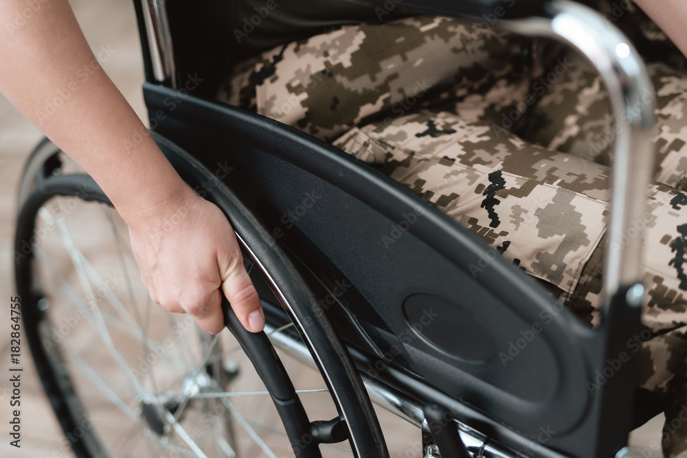 Woman veteran in wheelchair returned from army. Close-up photo veteran woman in a wheelchair.