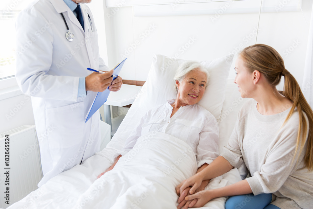 Obraz premium senior woman and doctor with clipboard at hospital