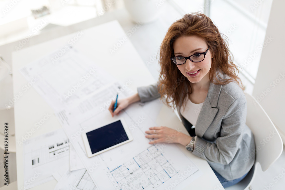 Young beautiful architect working on project in office Young beautiful architect working on project in office