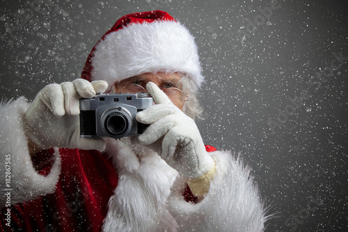 Santa Claus taking picture with old camera. photo