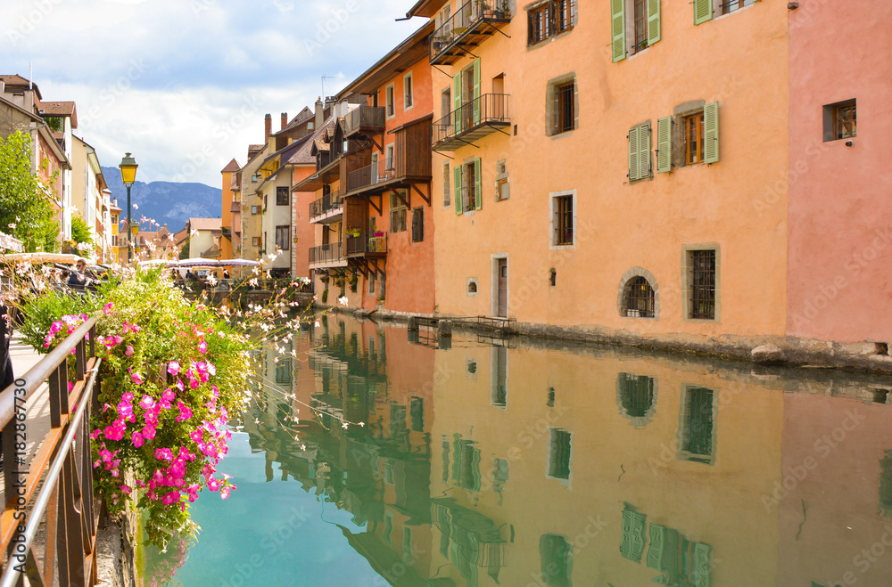 The city of Annecy. Historical medieval houses and a canal, embankment with flowers and bridges in the resort town of Annecy in France in the summer.