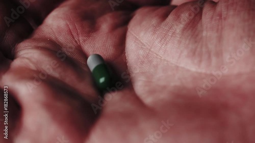 Pill falling in an open palm. Multiple takes.