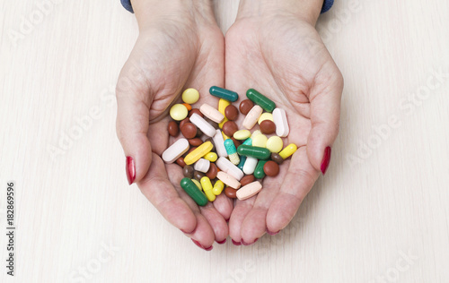 Two hands holding many color pills. Overdose or abuse concept