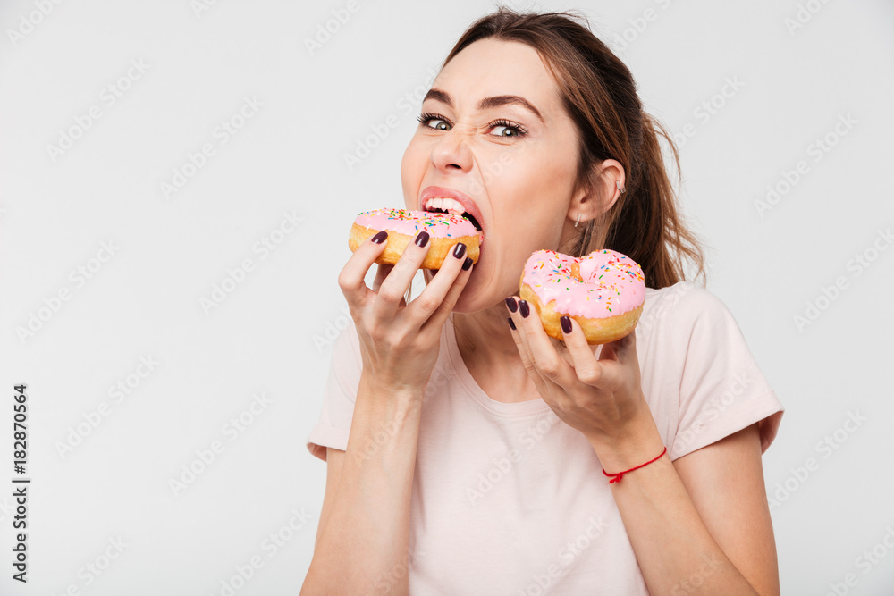 Close up portrait of a hungry greedy girl eating donuts Close up portrait of a hungry greedy girl eating donuts