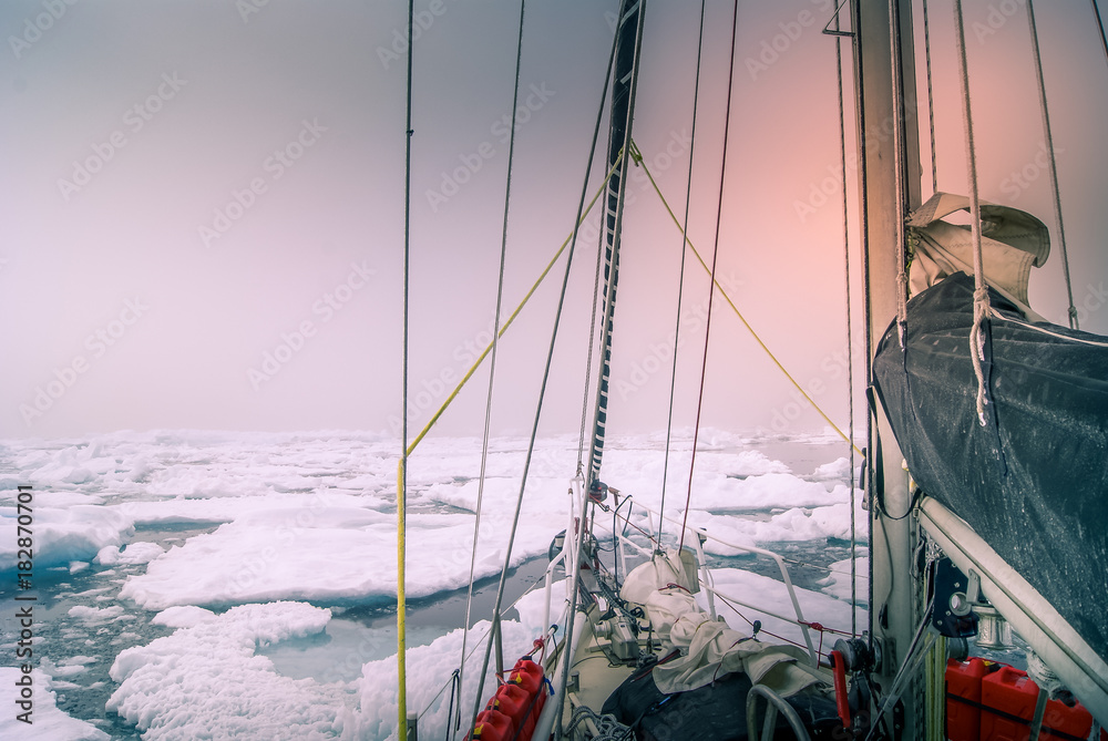 Naklejka premium Greenland, sailing boat trough the iceberg, risk, danger in the north pole
