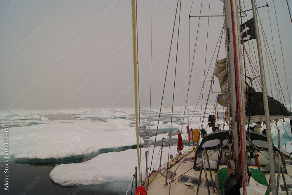 Obraz premium Greenland, arctic: sailing boat trough the iceberg, risk, danger