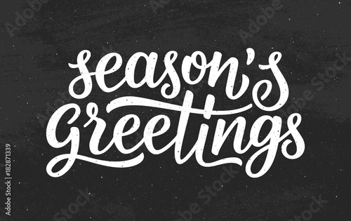 Seasons greetings calligraphy lettering text on black chalkboard background. Retro greeting card for Christmas and New Year holidays. Vector background