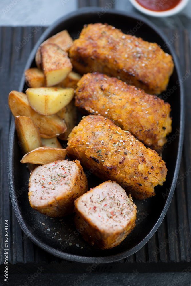 Close-up of schnitzels with turkey meat in a cast-iron pan, selective focus, vertical shot