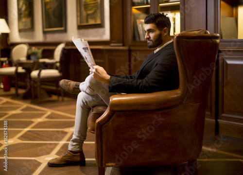 Modern businessman reading newspaper