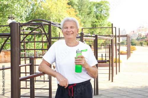 Mature man with bottle of w...