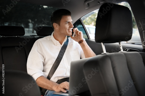 Young man talking on phone in car © Africa Studio