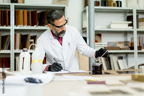 Engineer in the laboratory examines ceramic tiles